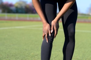 Sporty Muscular Young Woman Clutching Her Knee