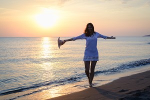 Beautiful woman smiling on beach. Happy people lifestyle. Woman smiling in sunset with arms outstretched. Nature lifestyle. Happiness. Lifestyle. Concept of happy lifestyle. Happy people. Happy young woman in vacation. Happiness concept. Young people.