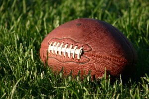 Picture of a football sitting in the grass.
